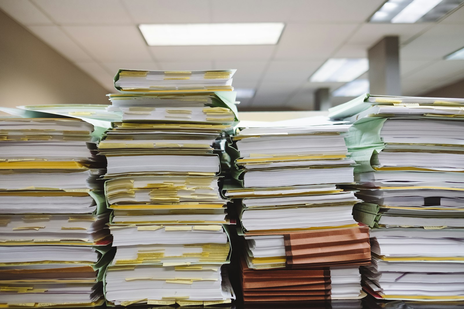 Pilhas de documentos e pastas de arquivo, representando a documentação do eSocial SST