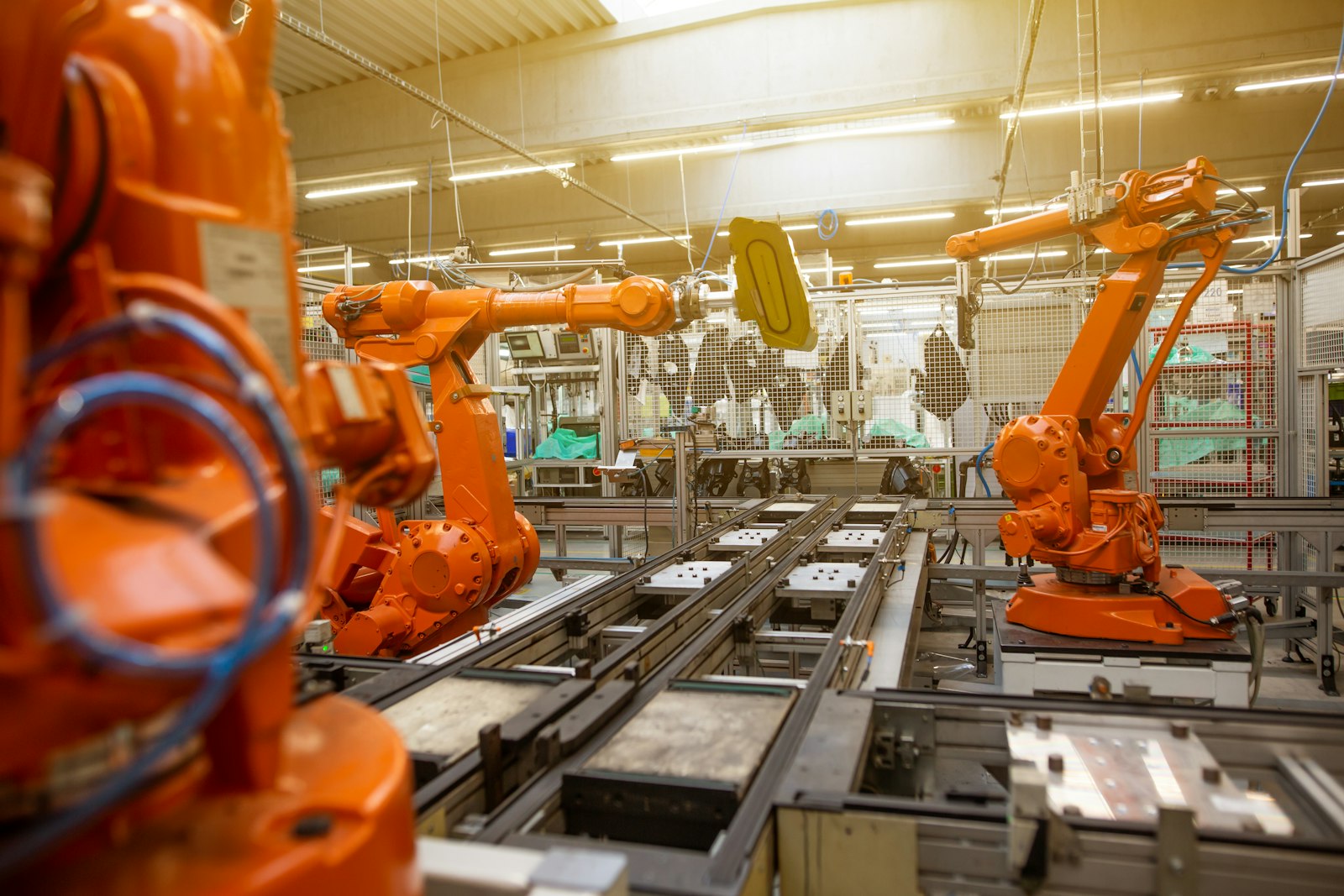 Braços robóticos em linha de produção industrial, ilustrando máquinas sujeitas à NR-12